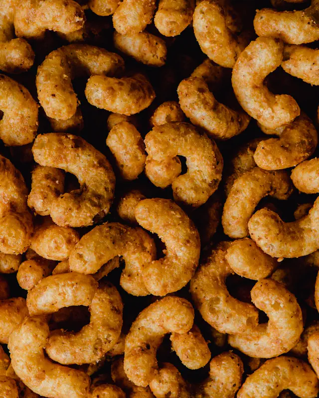Seasoned extruded corn puffs